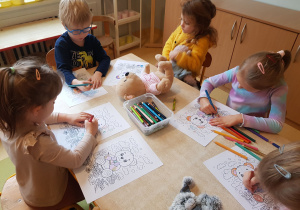 Dzieci kolorują obrazki z misiem