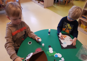 Chłopcy wykonują misiowe prace plastyczne