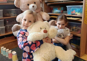 Trzy dziewczynki przytulają się do swoich misiów