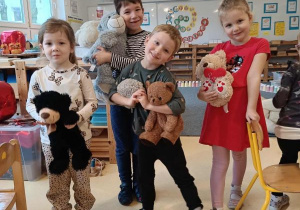 Dzieci stoją i przytulają się do swoich misiów