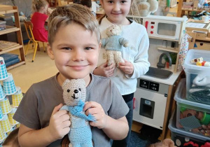 Chłopiec z dziewczynką pozują do zdjęcia ze swoimi misiami