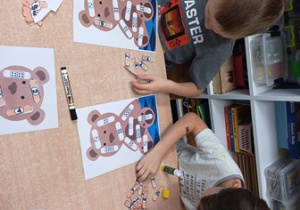 Chłopcy przyklejają samodzielnie wycięte plasterki