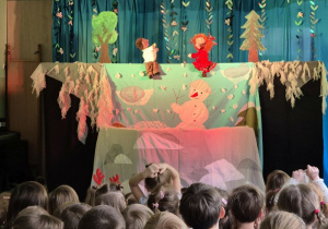 Scena oraz występujące na niej pacynki - chłopiec i dziewczynka, na widowni siedzą dzieci