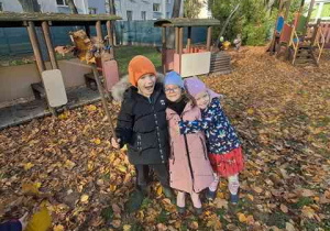 Dzieci pozują do zdjęcia w czasie prac ogrodowych - porządkowanie liści