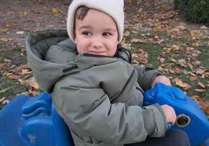 Chłopiec kołysze się na niebieskim bujaku