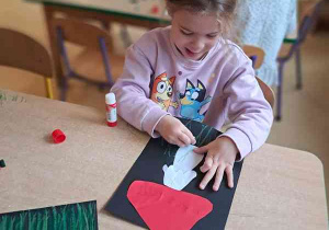 Pola przy stoliku podczas wykonywania pracy plastycznej przedstawiającej muchomora