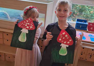 Zosia i Natan prezentują wykonane przez siebie prace plastyczne przedstawiające muchomora