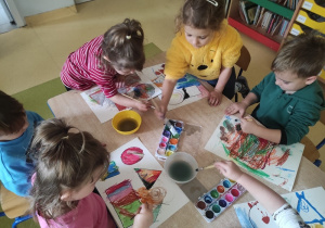 Dzieci malują farbami.