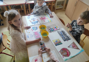 Dzieci malują farbami figury geometryczne.