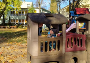 Chłopcy bawią się na statku w ogrodzie