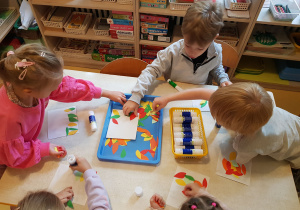 Dzieci przygotowują tło do pracy plastycznej