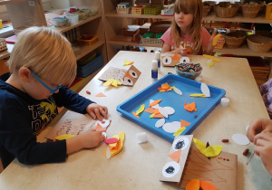 Dzieci konstruują sowy z papierowych torebek