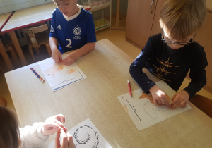 Dzieci kolorują kartę pracy z wiewiórką