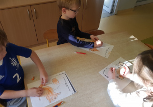 Dzieci kolorują kartę pracy z wiewiórką