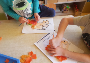 Dzieci ozdabiają ogon wiewiórki bibułą