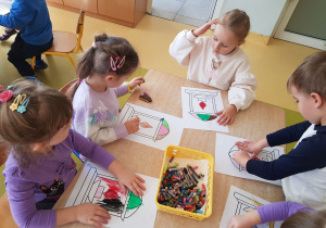 Dzieci podczas pracy plastycznej przedstawiającej znicze