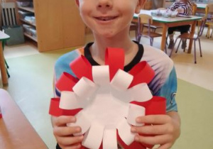 Natan prezentuje wykonany z papieru kotylion