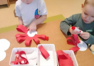 Chłopcy przy stoliku tworzą kotyliony