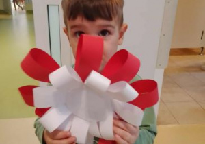 Miłosz pozuje do zdjęcia z własnoręcznie wykonanym kotylionem