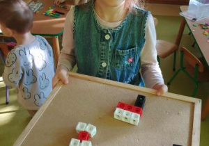 Tosia prezentuje swoje flagi Polski wykonane z klocków