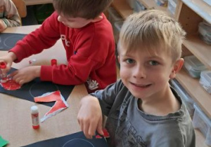 Chłopcy wyklejają czerwone światło na sygnalizatorze