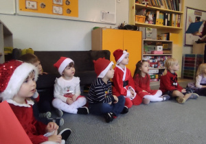 Dzieci w kręgu słuchają Mikołaja.