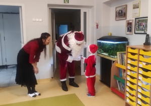 Chłopiec wita i zaprasza Mikołaja do grupy.