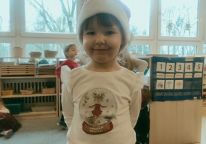 Dziewczynka w świątecznym stroju czeka na Mikołaja.