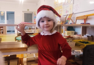 Dziewczynka w świątecznym stroju czeka na Mikołaja.