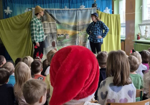 Aktor i aktorka podczas przedstawienia, dzieci siedzą na widowni