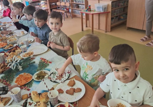 Dzieci podczas wigilijnego poczęstunku przy wspólnym stole