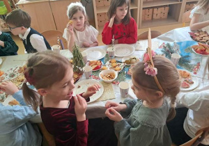 Dziewczynki dzielą się opłatkiem i składają życzenia