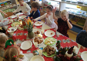 Dzieci siedzą przy wigilijnym stole