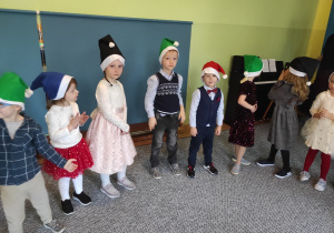 Dzieci w mikołajowych czapkach podczas świątecznego występu