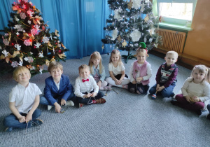 Dzieci siedzą na dywanie z instrumentami muzycznymi