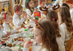 Dzieci siedzą przy wigilijnym stole