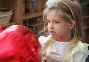 Dziewczynka podczas tańca z czerwonym balonem