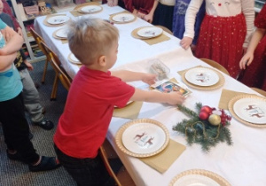 Kostas układa opłatek na stole