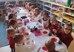 Dzieci siedzą przy wspólnym stole