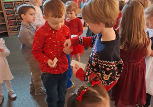 Dzieci składają sobie życzenia i dzielą się opłatkiem