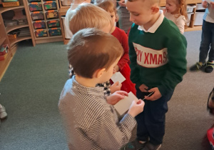 Dzieci składają sobie życzenia i dzielą się opłatkiem