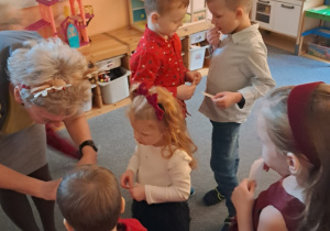 Dzieci składają sobie życzenia i dzielą się opłatkiem