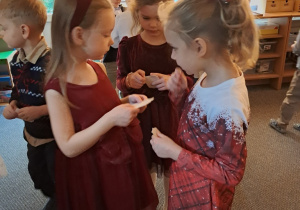 Dzieci składają sobie życzenia i dzielą się opłatkiem