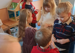 Dzieci składają sobie życzenia i dzielą się opłatkiem