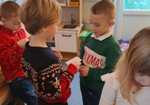 Dzieci składają sobie życzenia i dzielą się opłatkiem