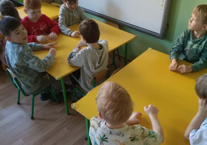 Dzieci siedzą przy stolikach
