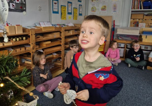 Chłopiec wiesza ozdobę na choince