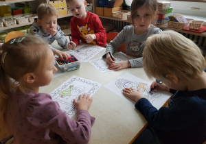 Dzieci kolorują obrazki z Mikołajem