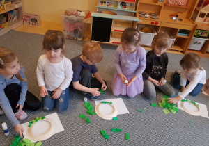 Dzieci przygotowują w parach wieńce świąteczne