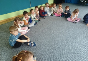 Dzieci siedzą na dywanie